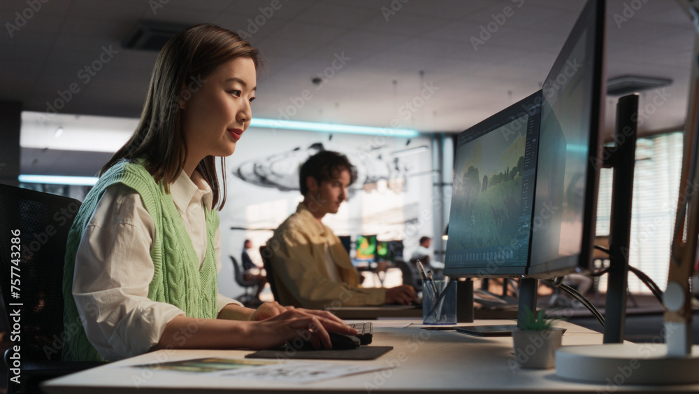 Poster Asian Woman Using Desktop Computer And Designing In 3D Modelling Software Unique World And Characters For Survival Video Game In Diverse Office. Female Game Developer Creating Immersive Gameplay