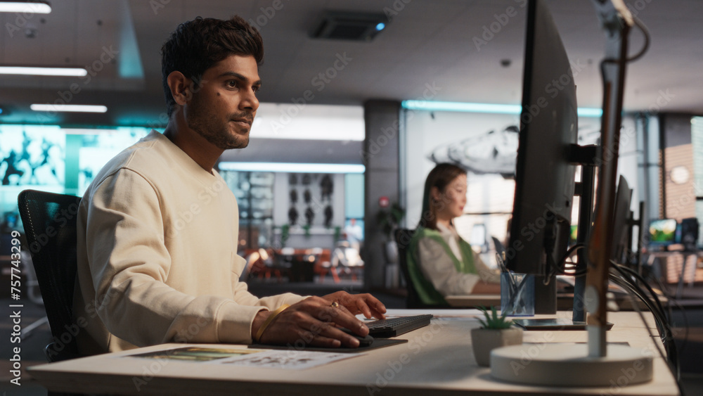 Aufkleber Indian Male Game Designer Using Desktop Computer With 3D Modelling Software To Design Unique Characters And World For Immersive RPG Video Game. Man Working In Game Development Company Diverse Office