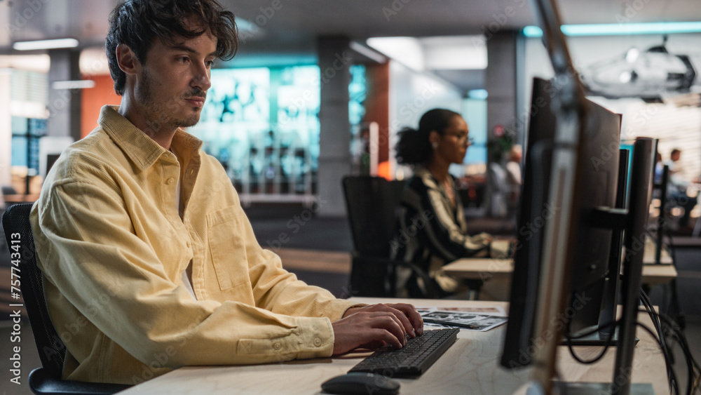 Aufkleber Male Caucasian Game Programmer Coding On Desktop Computer In Game Design Studio Diverse Office. Focused Man Writes Lines Of Code, Does Gameplay Engineering For New Immersive 3D Survival Video Game.