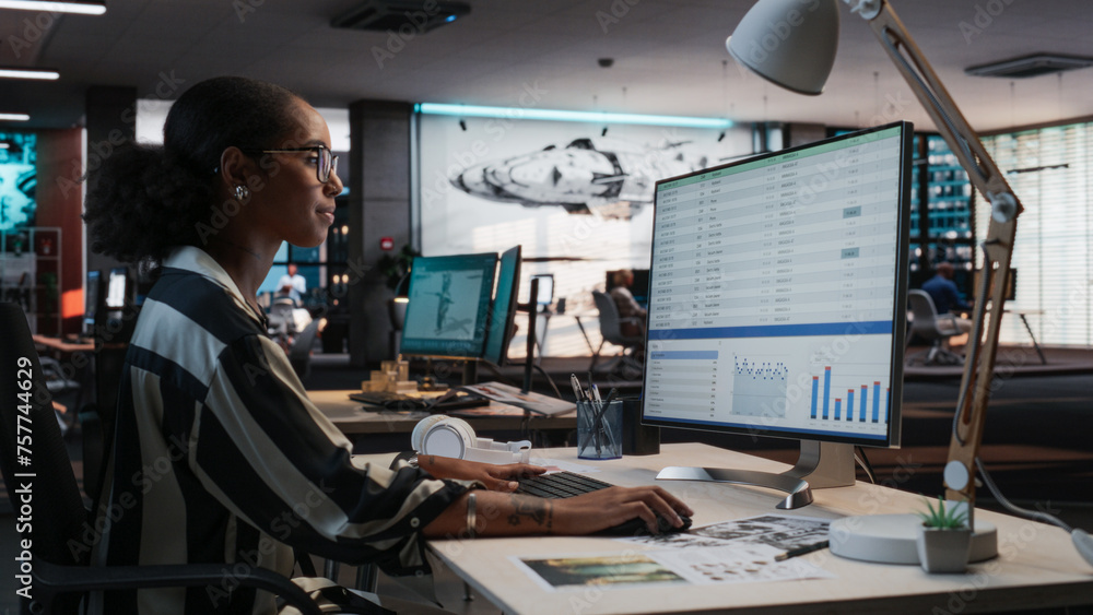Fototapete African Female Manager Using Desktop Computer With Analytics Software wth Financial Reports. Woman Working In Game Development Company Diverse Office