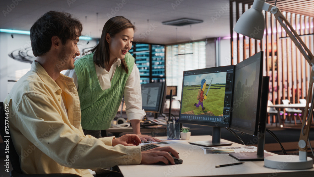 Poster Caucasian Male Game Developer Using Desktop Computer With 3D modelling Software And Talking to Asian Female Project Manager in Game Design Studio Office. Diverse Colleagues Discussing New RPG Game.