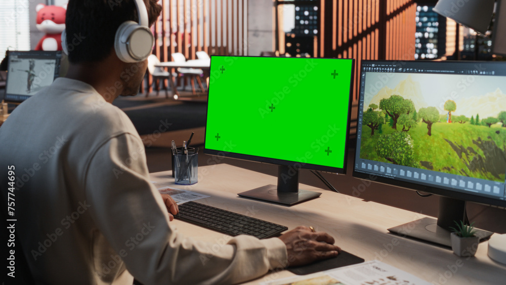 Aufkleber Indian Male Game Designer Using Desktop Computer With Green Screen Chromakey on Display, Designing Immersive World In 3D modelling Software For RPG Video Game. Man Working In Game Development Office