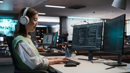 Female Asian Game Programmer Coding On Desktop Computer In Game Development Studio Diverse Office....
