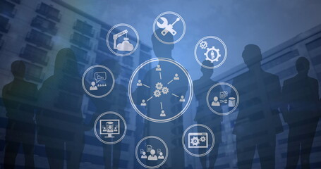 Image of network of digital icons over silhouettes of business people