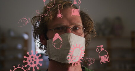 Image of covid 19 icons over man in pottery studio wearing face mask - Powered by Adobe