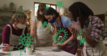 Image of virus icons over diverse workers with face masks forming pottery