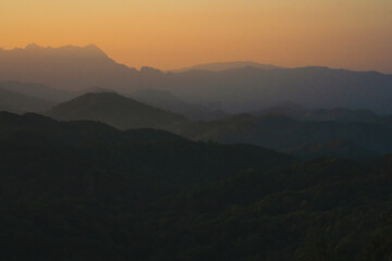 Fototapeta premium nature traveling with orange sky and layer of mountain with sunrise background