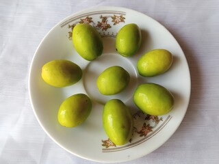 Fresh juicy jujube fruit in a plate isolated on white background.