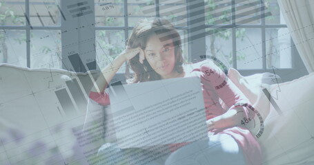 Image of financial data processing over woman using laptop at home