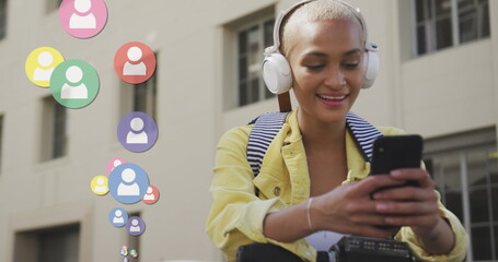 Image of social media icons over biracial woman using smartphone
