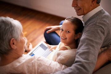 Child, grandparents and tablet on couch in home or online game or communication, teaching or connection. Elderly couple, retirement and girl or internet learning in apartment, development or bonding