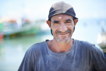 Fisherman, portrait and rugged man with smile, harbour and wrinkles from sunlight exposure. Boats,...