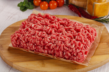 Raw minced beef meat over board