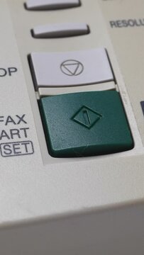 Male Finger Presses The Start Button On Old White Fax. Vertical.
