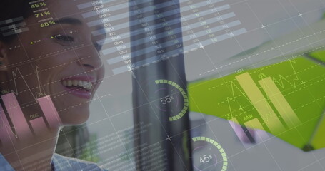 Image of statistics and data processing over woman using laptop