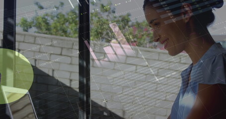 Image of statistics and data processing over woman using laptop