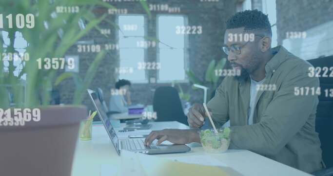 Image of data processing over african american businessman using laptop in office