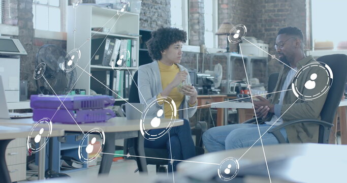 Image of user icons over diverse business people having lunch in office