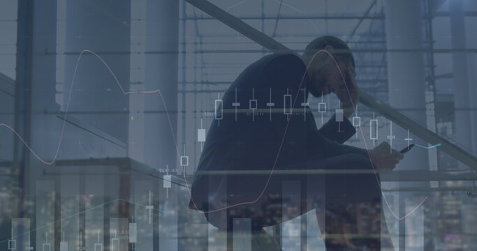 Image of financial graph over biracial businessman using smartphone