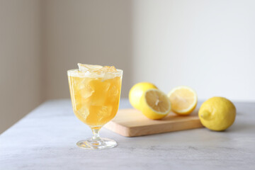 A group of yellow lemonade and lemon slices and copy space on a beautiful gray table with light coming through the natural light window