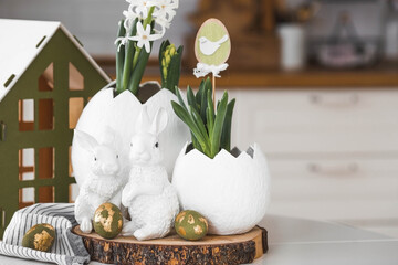 Happy Easter. A spring hyacinth flower in an egg-shaped vase, Easter bunnies and eggs with a golden...