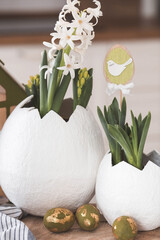 Happy Easter holiday. A spring hyacinth flower in an egg-shaped vase, Easter bunnies and eggs with...