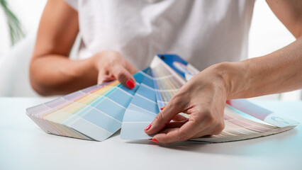 A designer meticulously selects colors from a palette, exploring creative options for their project.