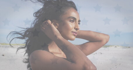 Image of flag of united states of america over biracial woman on beach
