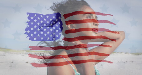 Image of flag of united states of america over biracial woman on beach