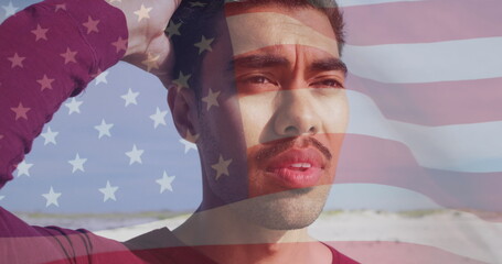 Image of flag of united states of america and biracial man on beach