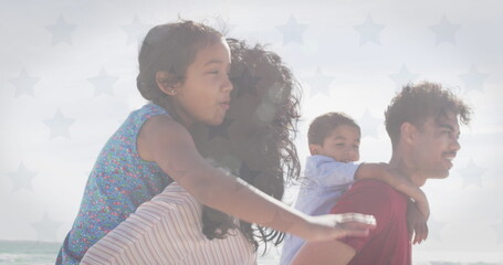 Image of flag of united states of america over biracial couple with son and daughter piggyback