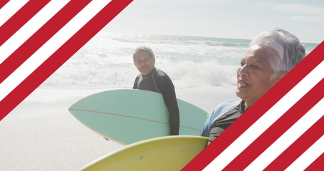 Image of flag of united states of america over senior biracial couple with surfboard on beach