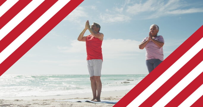Image of flag of united states of america over senior biracial couple practicing yoga on beach