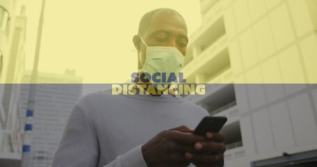 Image of covid 19 social distancing text over african american man using smartphone in face mask