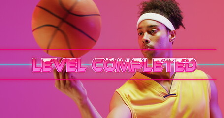 Image of level completed text over neon pattern and biracial basketball player