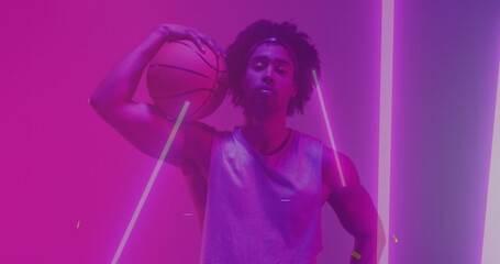 Image of confetti and neon pattern and biracial basketball player