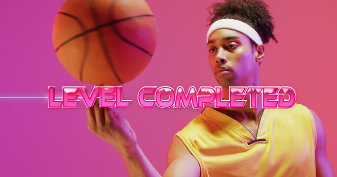 Image of level completed text over neon pattern and biracial basketball player