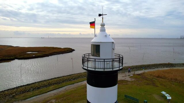 Lighthouse “Little Preusse” - Wurster North Sea Coast - Wremen - Northern Germany - circling flight aerial view around the tower at the entrance to the cutter harbor