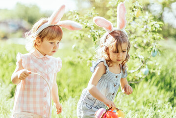 Easter egg hunt. Group Of Children Wearing Bunny Ears Running To Pick Up colorful Egg On Easter Egg Hunt In Garden. Easter tradition - 757786609