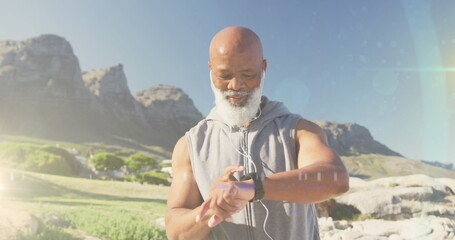 Image of glowing light over happy senior man exercising outdoors