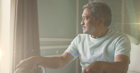 Image of glowing light over portrait of pensive senior man