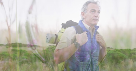 Image of spinning meadow over senior man hiking with backpack