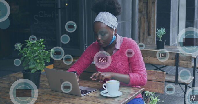 Image of 5g and 6g icons over african american woman using laptop outside cafe