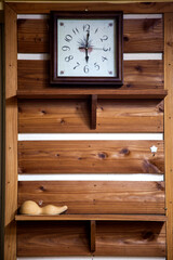 View of the clock on the wooden wall and a gourd on a shelf