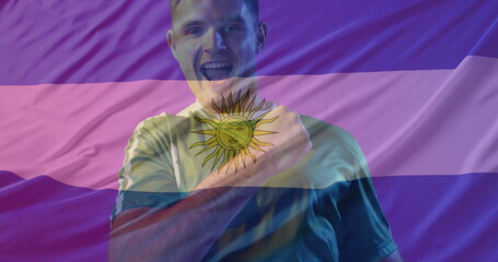 Image of caucasian male soccer player over flag of argentina