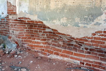 Distressed brick wall in the old destroyed abandoned building. Weathering and degradation
