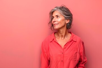 Obraz premium A woman in a red shirt is looking at the camera with a smile on her face