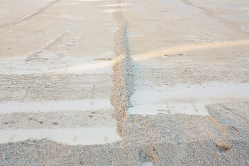 Preparation of a layer of sand for the assembly of a concrete draining floor ina a construction site