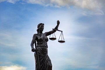 Sculpture of Lady Justice or Themis symbol of justice and law in Izmir Turkey, Femida outdoors against blue cloudy sky background copy space cut out