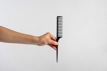 Black hair comb in hand isolated on white background